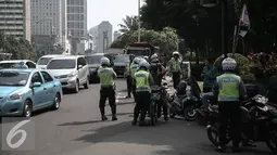 Suasana petugas saat operasi patuh jaya dikawasan Thamrin, Jakarta, Selasa (24/5/2016). Selama Operasi Patuh Jaya 2016, Ditlantas Polda Metro Jaya mencatat terjadi 38.622 pelanggar lalu lintas. (Liputan6.com/Faizal Fanani)