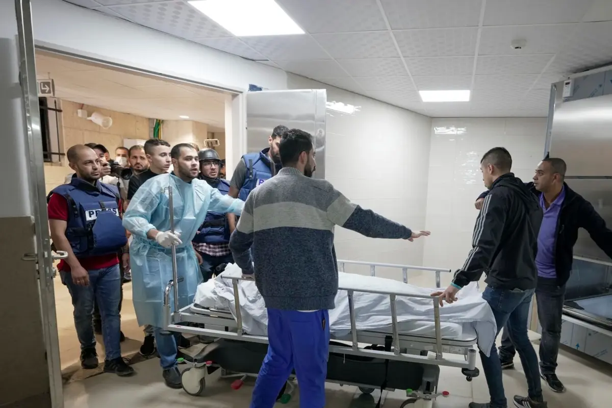 Para jurnalis dan petugas medis tampak membawa jenazah Shiren Abu Akleh, jurnalis Al Jazeera yang tewas tertambak oleh pasukan Israel, ke dalam kamar mayat di salah satu rumah sakit di Jenin, Tepi Barat, pada 11 Maret 2022. (Foto: AP/Majdi Mohammed)