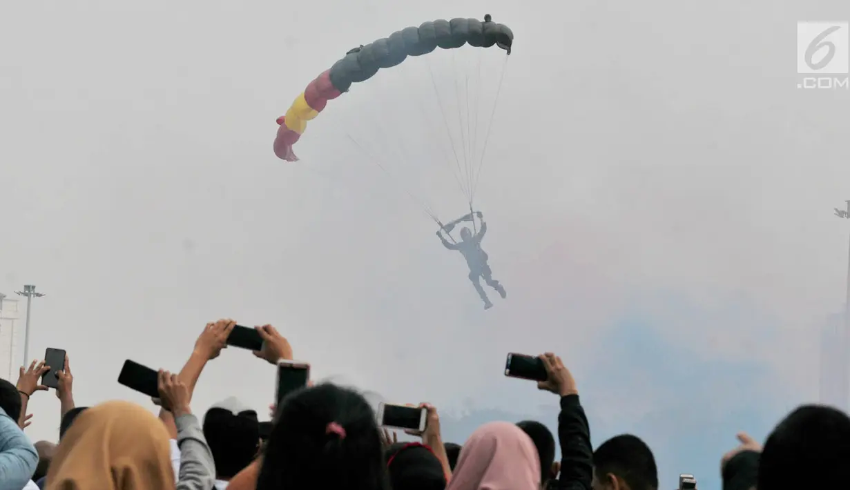 Penerjun payung bersiap mendarat saat Festival Damai Millenial Road Safety di Monas, Jakarta, Minggu (23/6/2019). Aksi puluhan penerjun payung TNI-Polri ini menjadi perhatian warga di akhir acara Festival Damai. (merdeka.com/Iqbal Nugroho)