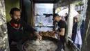 Warga Palestina membuat falafel, makanan yang disukai untuk berbuka puasa, selama bulan suci Ramadhan di pusat kota Hebron di Tepi Barat yang diduduki (9/4/2022). Falafel adalah sebuah makanan Timur Tengah. (AFP/Hazem Bader)