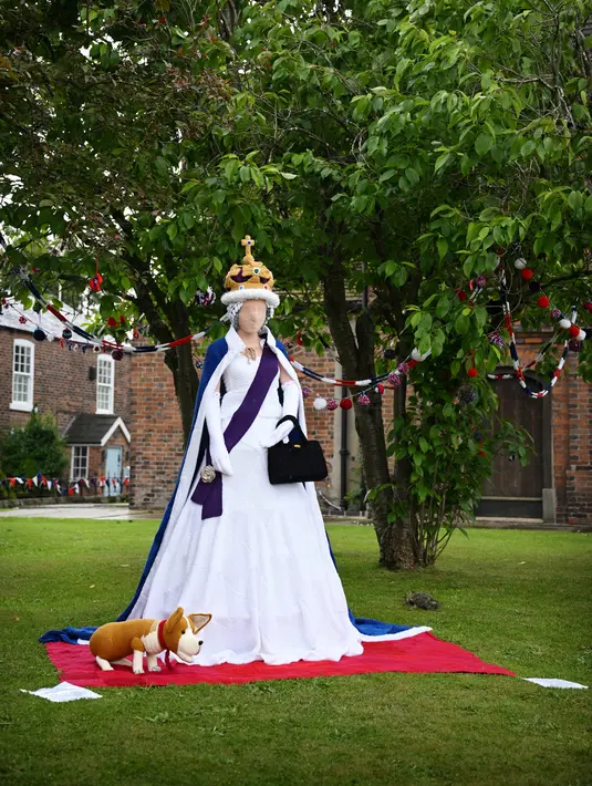 Ratu Elizabeth II dari Inggris yang dirajut seukuran manusia terlihat di halaman Gereja St Luke di Kapel Holmes, barat laut Inggris, pada 30 Mei 2022. Sebuah kelompok masyarakat lokal, The Holmes Chapel Community Yarn Bombers telah memenuhi desa dengan barang-barang rajutan patriotik untuk merayakan Platinum Jubilee Ratu. (Paulus ELLIS / AFP)