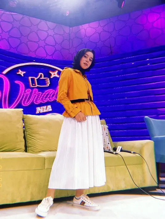 Kombinasi blouse peplum warna kuning mustard dengan rok rempel warna putih dan hijab warna hitam juga tak kalah menarik. (Instagram/lestykejora).