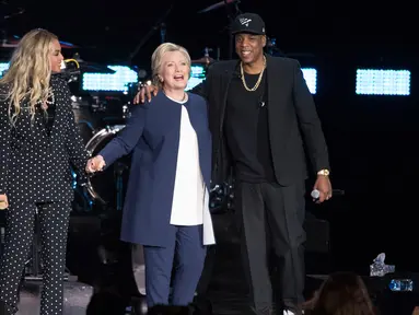 Penyanyi Beyonce dan suaminya, Jay Z berdiri bersama Capres AS Hillary Clinton dalam konser kampanye di Cleveland, Ohio, Jumat (4/11). Jay Z dan Beyonce menggelar konser bagi Hillary untuk meraih pemilih muda berkulit hitam di Ohio. (AP Photo/Matt Rourke)