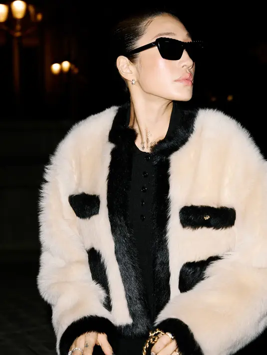 Peggy Gou tampil slay dengan knitwear hitam berlapis jaket berbulu berkantung dari Chanel [Chanel]