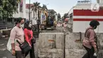 Pejalan kaki saat melintas di dekat proyek revitalisasi pedestrian kawasan Kota Tua, Jakarta, Minggu (27/3/2022). Jalur pedestrian itu akan diubah menjadi plaza pedestrian yang lebar sebagai bagian dari penataan kawasan Kota Tua yang rendah emisi (merdeka.com/Iqbal S Nugroho)