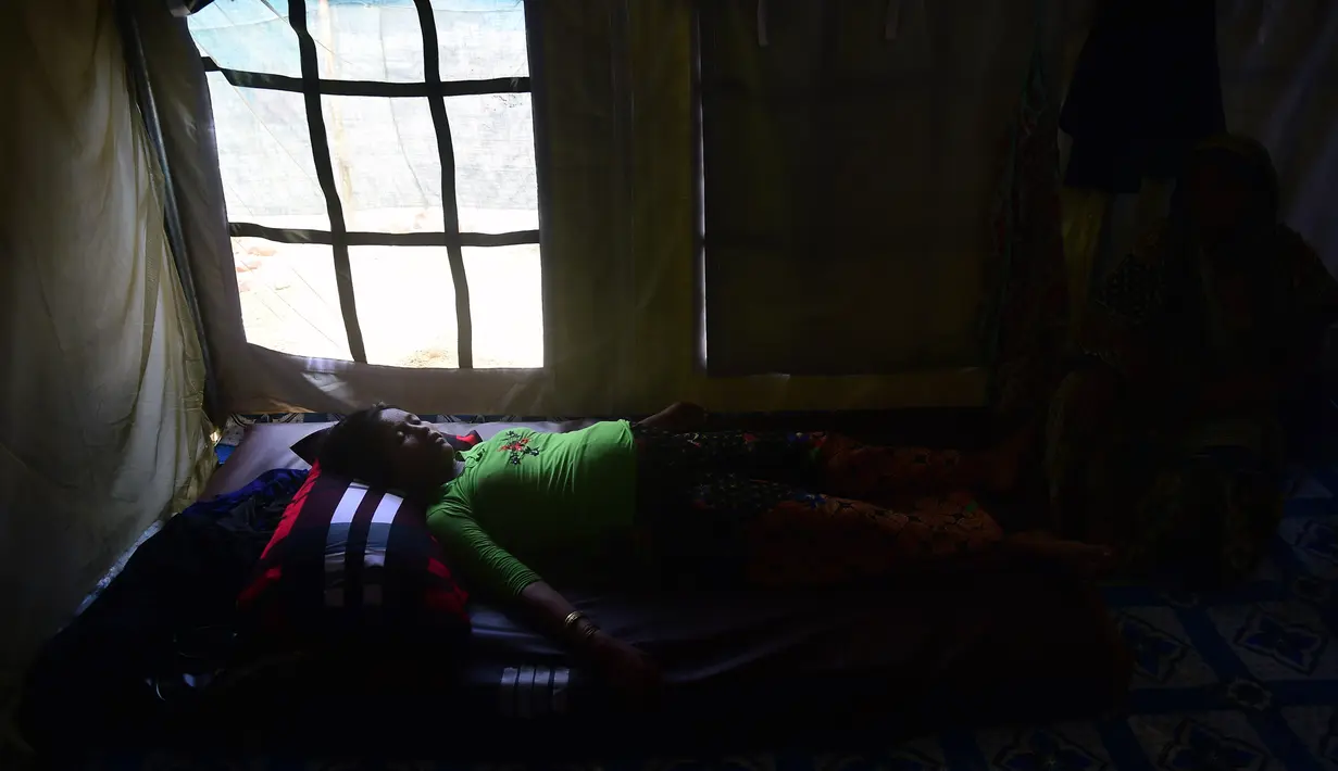 Seorang wanita Rohingya bernama Hasina Aktar yang sedang hamil bersiap melakukan persalinan di kamp pengungsian Kutupalong (11/10). (AFP Photo/Munir Uz Zaman)