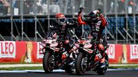 Pembalap MotoGP Italia dari tim Aprilia Racing, Marco Bezzecchi (kanan), merayakan kemenangannya dalam sprint race MotoGP Grand Prix Australia bersama rekan setim sekaligus rekan senegaranya, Lorenzo Savadori, di Phillip Island pada 18 Oktober 2025. (Paul CROCK/AFP)