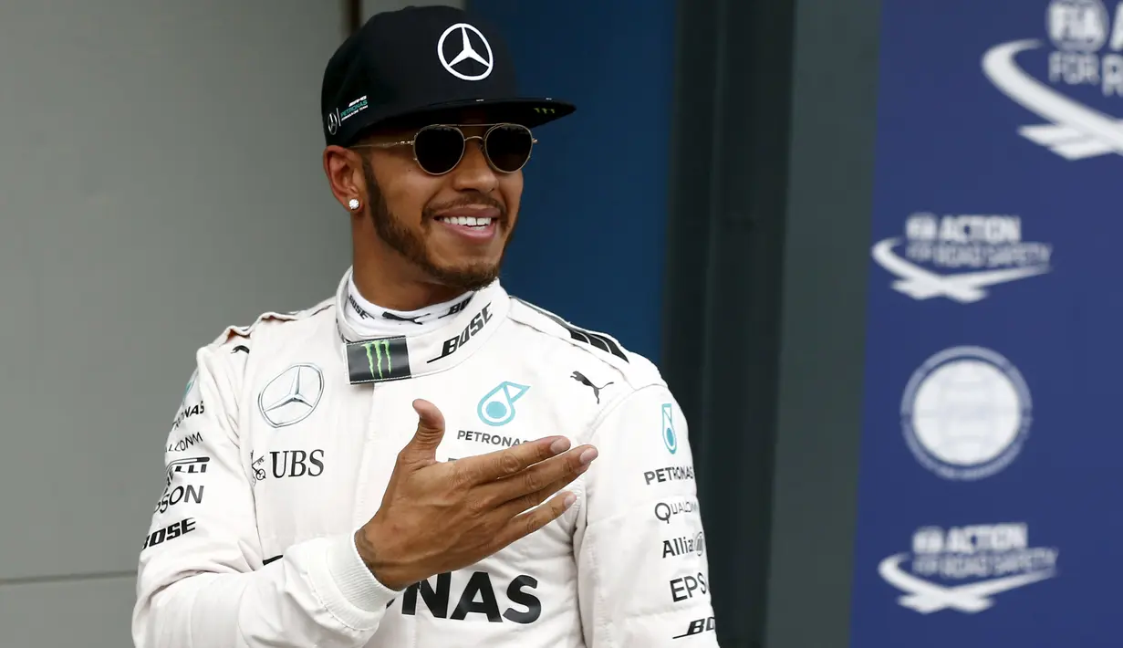 Pembalap Mercedes F1 Lewis Hamilton tersenyum usai kualifikasi di Australian Formula One Grand Prix di Melbourne (19/3). Lewis Hamilton menjadi yang tercepat pada sesi kualifikasi Formula 1 2016 di Sirkuit Albert Park. (REUTERS/Jason Reed)