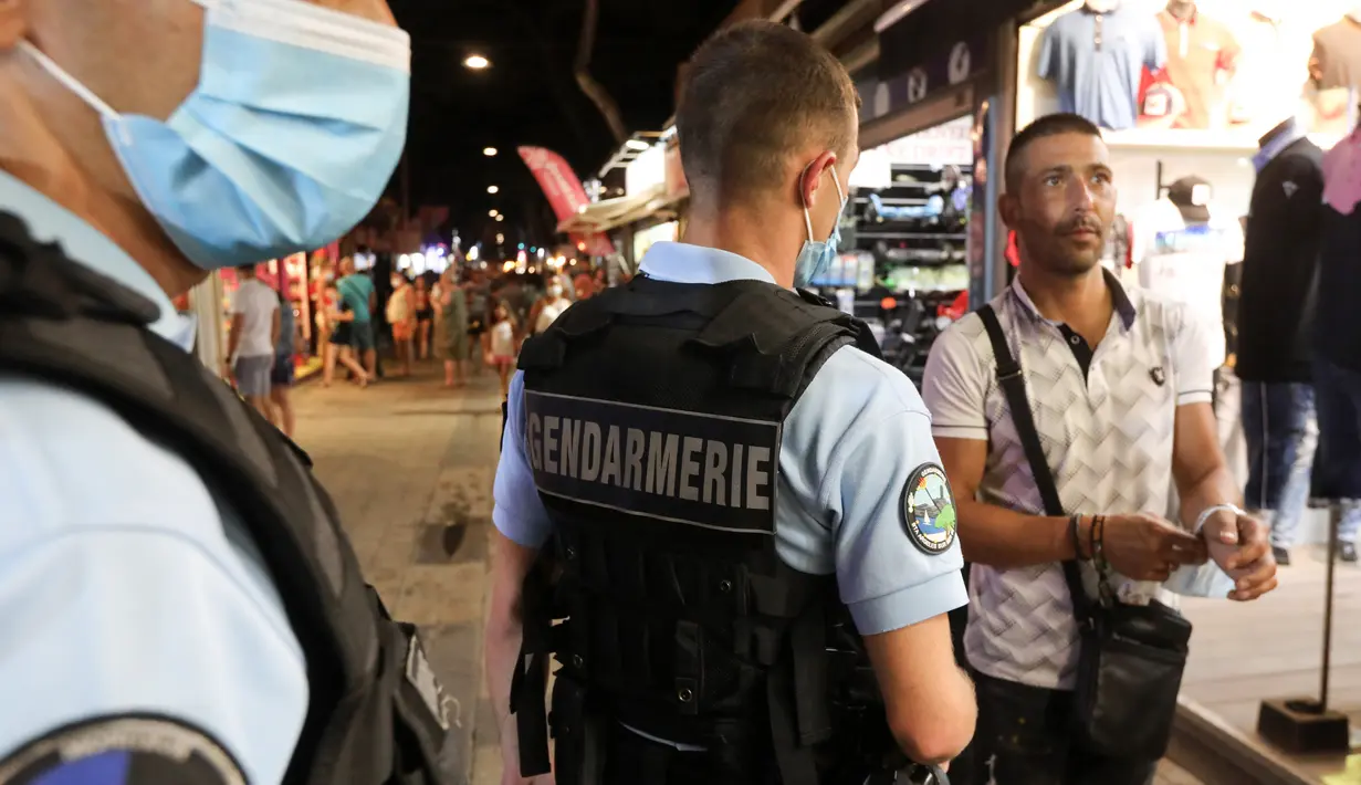 Polisi Prancis berpatroli untuk mengontrol kewajiban penggunaan masker di jalan-jalan Argeles-sur-Mer, Prancis selatan, Rabu (13/8/2020). Pemakaian masker di beberapa area ramai di sekitar Paris merupakan kewajiban sebagai upaya untuk membendung peningkatan tajam infeksi covid-19. (RAYMOND ROIG/AFP)