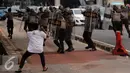 Massa melempari aparat Kepolisian dengan batu di depan kantor KPK, Jakarta, Jumat (20/5). Aksi menuntut KPK untuk segera mengusut keterlibatan Ahok di Sumber Waras ini berakhir ricuh. (Liputan6.com/Yoppy Renato)