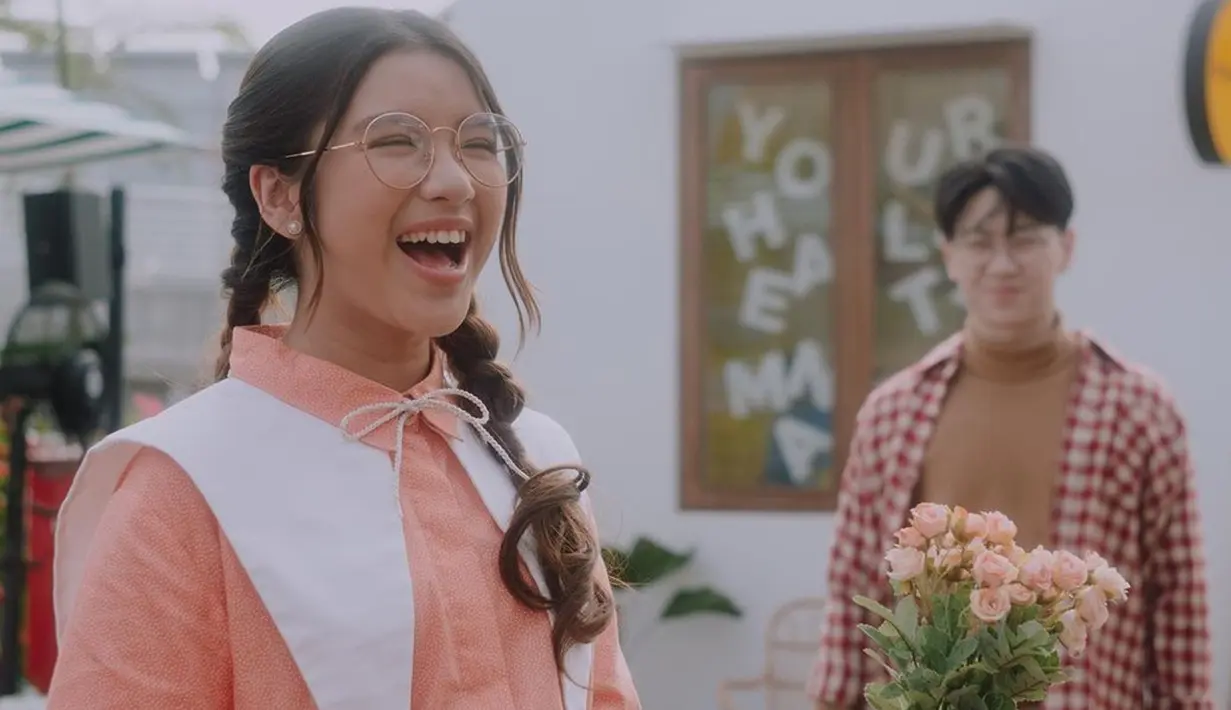 Penampilaan Tiara Andini saat syuting video klip terbarunya dengan busana vintage. Penyanyi muda asal Jember ini tampil chic dengan kacamata bening dan kemeja retro. (Liputan6.com/IG/@tiaraandini)