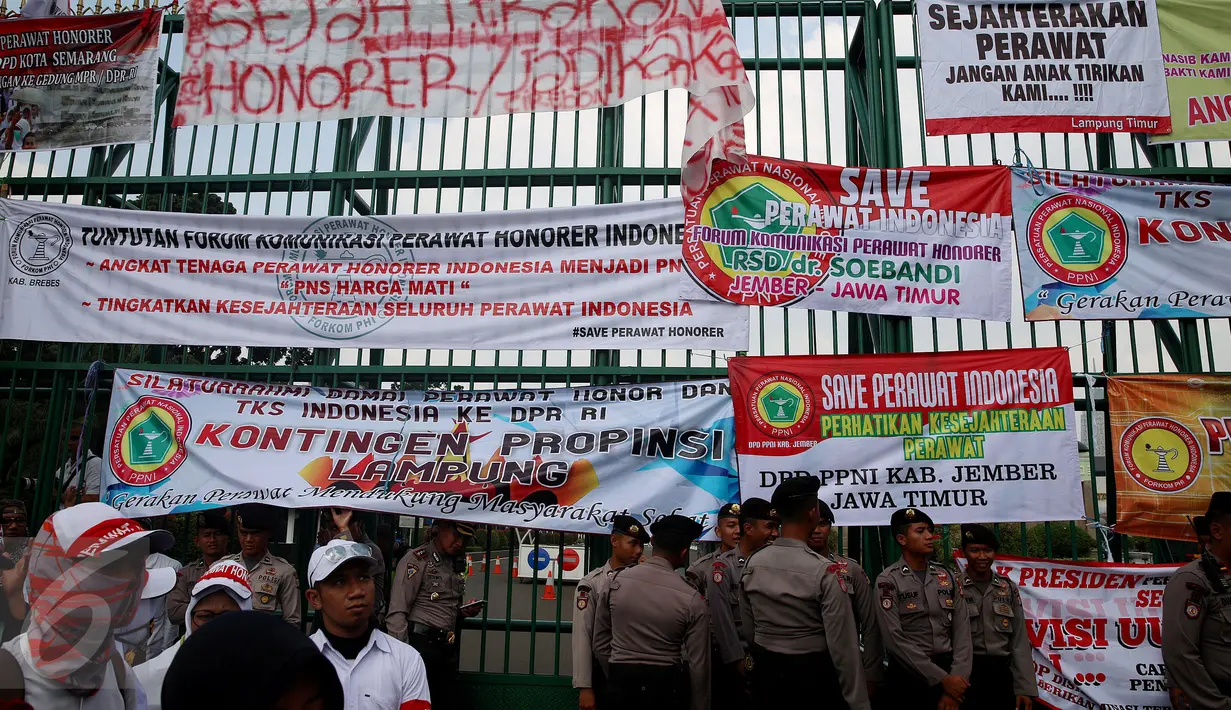 Petugas kepolisan menjaga aksi unjuk rasa yang digelar para perawat honorer Indonesia di depan Gedung DPR, Jakarta, Kamis (16/3). (Liputan6.com/Johan Tallo)