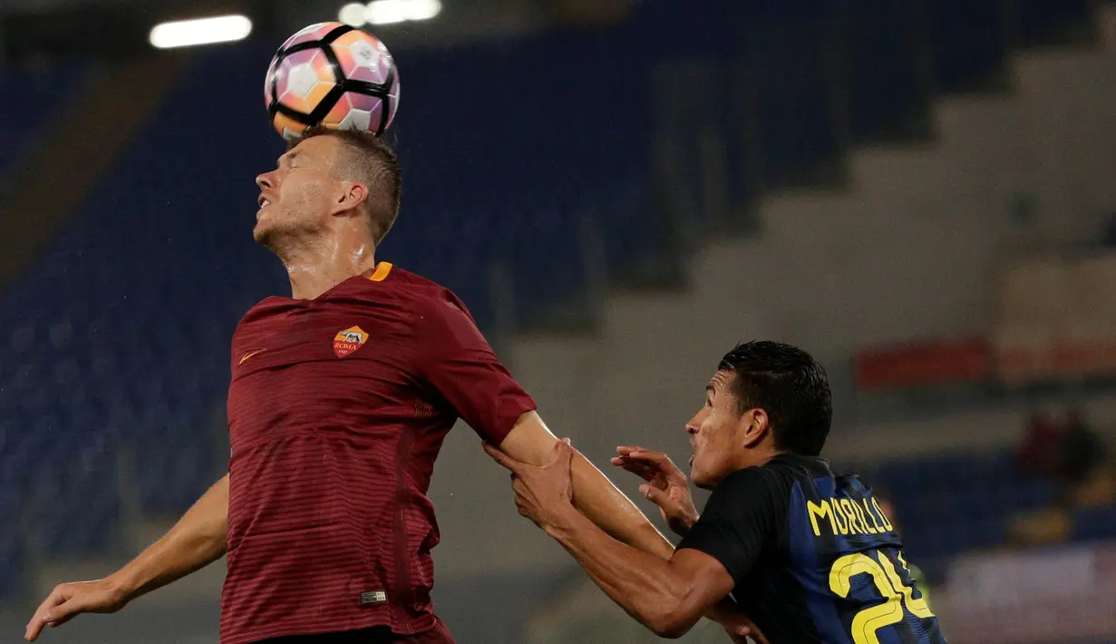 Pemain AS Roma, Edin Dzeko (kiri) menyundul bola saat dihadang pemain Inter Milan, Jeison Murillo pada lanjutan Serie A Italia di Stadion Olympico, Roma, Senin (3/10/2016) dini hari WIB. (REUTERS/Max Rossi)