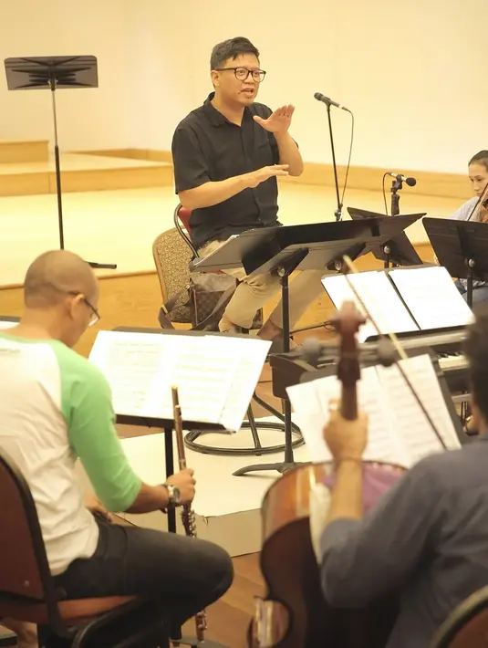 Konduktor Avip Priatna memimpin latihan Jakarta Concert Orchestra (JCO) di Balai Resital Kertanegara, Jakarta, Rabu (28/11). Konser Beat It-A Tribute To Michael Jackson akan dilangsungkan di Taman Ismail Marzuki. (Fimela.com/Bambang Purnama)