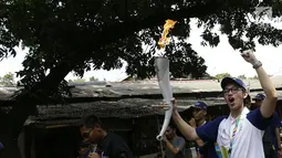 Aktor Brandon Salim berlari membawa obor Asian Games saat Torch Relay Asian Games 2018 di Cipayung, Jakarta Timur, Rabu (15/8). Api Asian Games akan diarak mengelilingi 5 Kota dan 1 Kabupaten di Provinsi DKI Jakarta. (Kapanlagi.com/Agus Apriyanto)