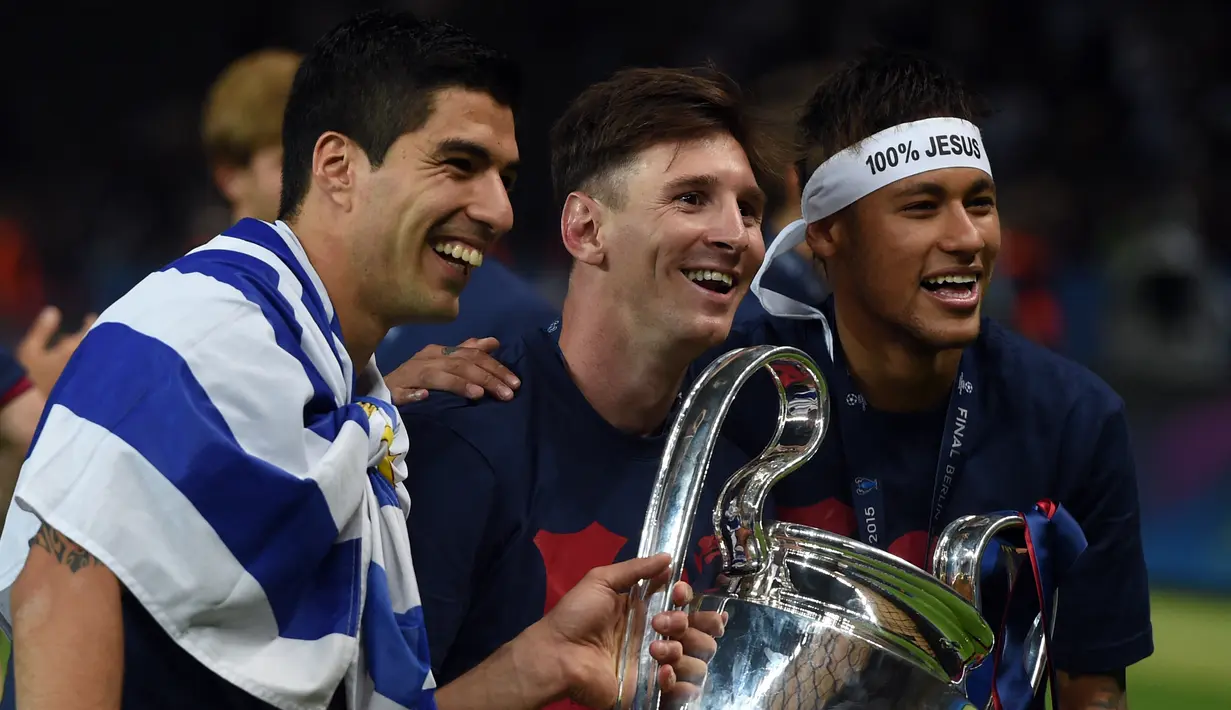 Lionel Messi (tengah) membawa trofi Liga Champions bersama Luis Suarez dan Neymar setelah menang melawan Juventus pada Final di Stadion Olimpiade di Berlin pada Juni 6, 2015. Messi sudah berstatus tanpa klub sejak tanggal 1 Juli 2021 mengingat kontraknya bersama Barcelona usai. (AFP/Patrik Stollarz)