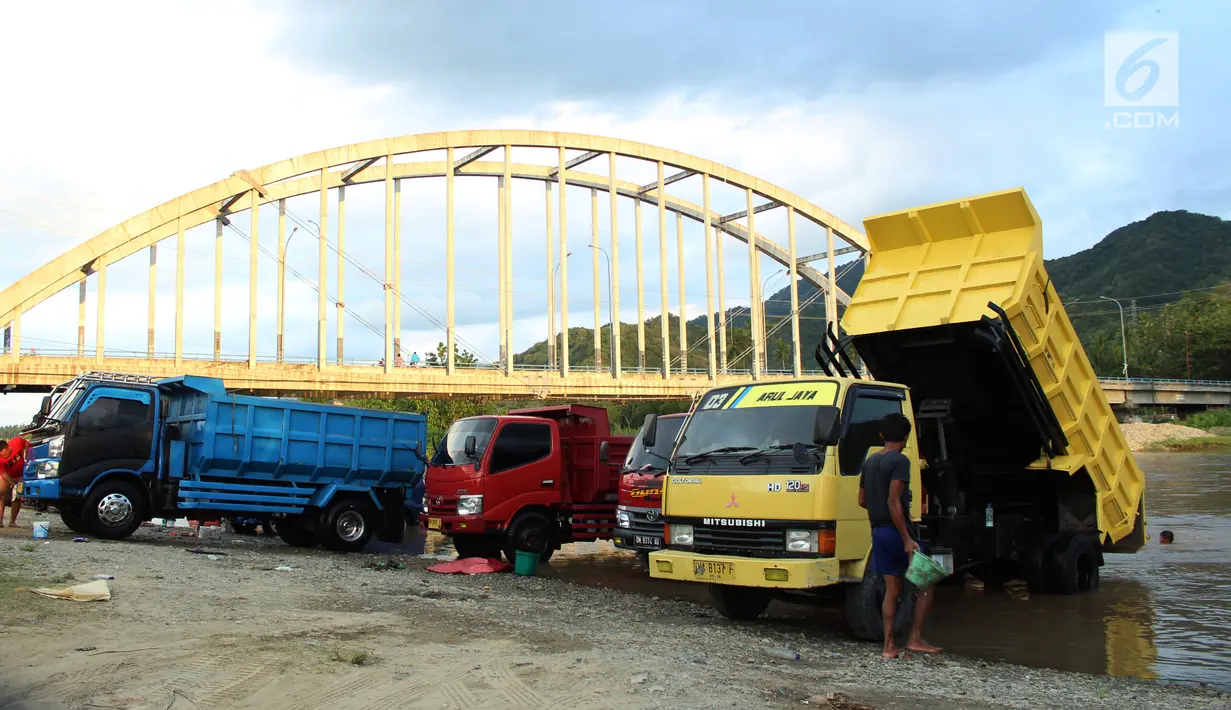 Sejumlah orang mencuci truk dengan memanfaatkan aliran sungai Bone di kompleks Jembatan Talumolo II, Kelurahan Talumolo, Gorontalo, Senin (19/11). Tempat itu menjadi kawasan pencucian kendaraan bermotor yang gratis.  (Liputan6.com/Arfandi Ibrahim)
