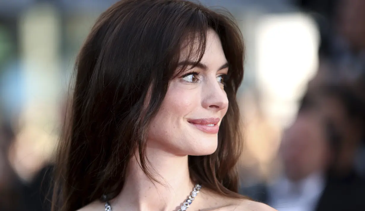 <p>Anne Hathaway berpose untuk fotografer setibanya di pemutaran perdana film 'Armageddon Time' di festival film internasional ke-75, Cannes, Prancis selatan (19/5/2022). Anne Hathaway tampak elegan dalam gaun Armani Prive tanpa tali di karpet merah. (AP Photo/Vianney Le Caer)</p>