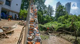 Aktivitas petugas UPK Badan Air DLH Provinsi DKI Jakarta saat memperbaiki tembok Kali Krukut yang jebol di Jalan Taman Kemang, Jakarta, Selasa (23/2/2021). Jebolnya tembok tersebut mengakibatkan kawasan kemang dan sekitarnya terendam banjir pada 20 Februari 2021. (Liputan6.com/Faizal Fanani)