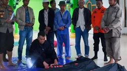 Foto selebaran yang diambil dan dirilis pada 7 Maret 2023 oleh kantor Kementerian Komunikasi dan Informatika Natuna ini menunjukkan para pejabat berdoa untuk para korban tanah longsor di Natuna, Kepulauan Riau (Kepri). Evakuasi terus dilakukan dengan kewaspadaan tinggi karena tanah masih labil dan masih terjadi longsor susulan. (HO / Natuna ministry of communication / AFP)