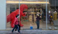 Seorang pekerja membersihkan pintu kaca toko barang mewah di sebuah pusat perbelanjaan di Beijing, China, Senin (6/3/2023). Pejabat ekonomi China menyatakan keyakinannya bahwa mereka dapat memenuhi target pertumbuhan tahun ini sekitar 5 persen dengan menghasilkan 12 juta pekerjaan baru dan mendorong pengeluaran konsumen setelah berakhirnya kontrol antivirus yang membuat jutaan orang tetap di rumah. (AP Photo/Mark Schiefelbein)