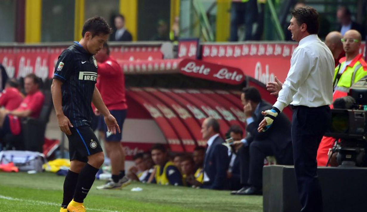 Gelandang Inter Milan, Yuto Nagatomo (kiri), tertunduk keluar lapangan usai mendapat kartu merah saat berlaga melawan Cagliari di Stadion San Siro, Milan, (28/9/2014). Inter Milan kalah 1-4 dari Cagliari. (AFP PHOTO/Giuseppe Cacace)