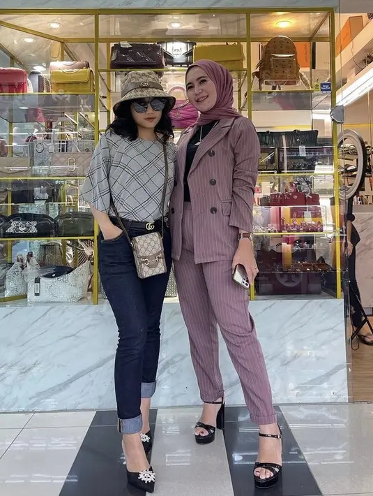 Perempuan berusia 17 tahunan ini tampil dengan bucket hat dan phone holder Gucci seharga Rp16 jutaan. Dipadukan dengan blouse grey geometris dan celana denim. Untuk alas kaki, ia memilih mengenakan heels hitam membuat kakinya tampak jenjang. (@fuji_an)