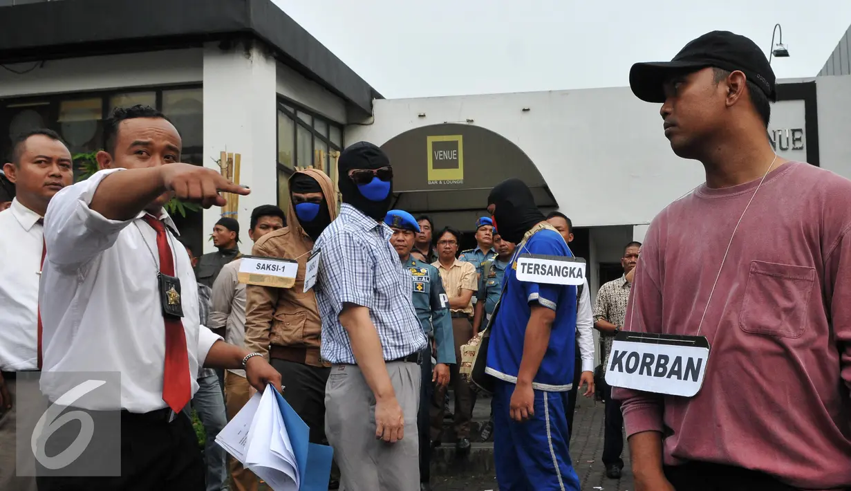 Tersangka JL mengikuti proses rekonstruksi pembunuhan aktivis Jopi Peranginangin, Kemang, Jakarta, Kamis (11/06/2015). Proses rekonstruksi tersebut terdiri dari 31 reka adegan yang diperankan oleh tersangka dan saksi-saksi. (Liputan6.com/Andrian M Tunay)