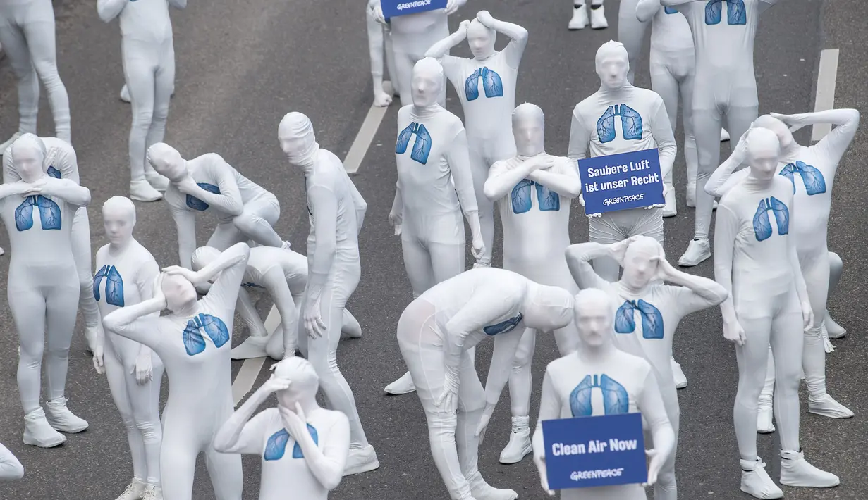 Aktivis dari Greenpeace mengenakan pakaian serba putih melakukan aksi teatrikal saat turun ke jalan di Stuttgart, Jerman (19/2). Mereka melakukan aksi memprotes polusi yang diakibatkan oleh knalpot mobil diesel. (Sebastian Gollnow/dpa/AFP)