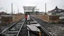 Warga melintas di jalur baru rel Double Double Track (DDT) di lintasan rel kereta api, Cikarang, Jawa Barat, (8/2). Proyek pembangunan rel ganda KRL dan kereta jarak jauh jalur Cikarang-Manggarai tersebut hampir selesai. (Liputan6.com/Gempur M Surya)