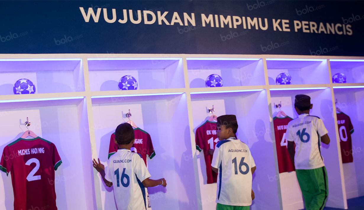 Anak-anak peserta final Aqua Danone Nations Cup 2016 melihat-lihat baju yang bertuliskan nama eks peserta yang kini sudah menjadi pemain nasional. (Bola.com/Vitalis Yogi Trisna)