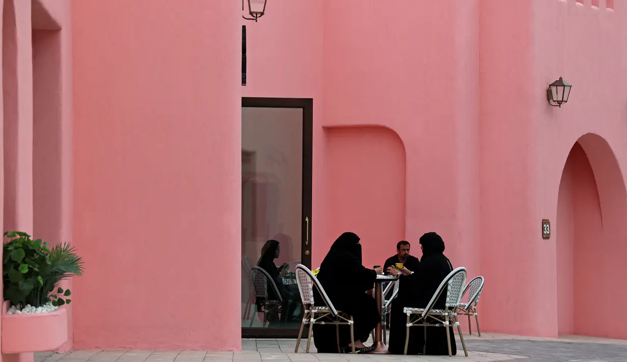 Warga Qatar duduk di sebuah kafe selama ajang Piala Dunia 2022 Qatar di Distrik Mina Doha pada 10 Desember 2022. Dari Distrik Mina, wisatawan bisa mengunjungi kawasan Pelabuhan Doha, Flag Plaza, Box Park, MIA dan tamannya, hingga Corniche, Souq Waqif, dan Taman Al Bidda. (AFP/Christina Assi)
