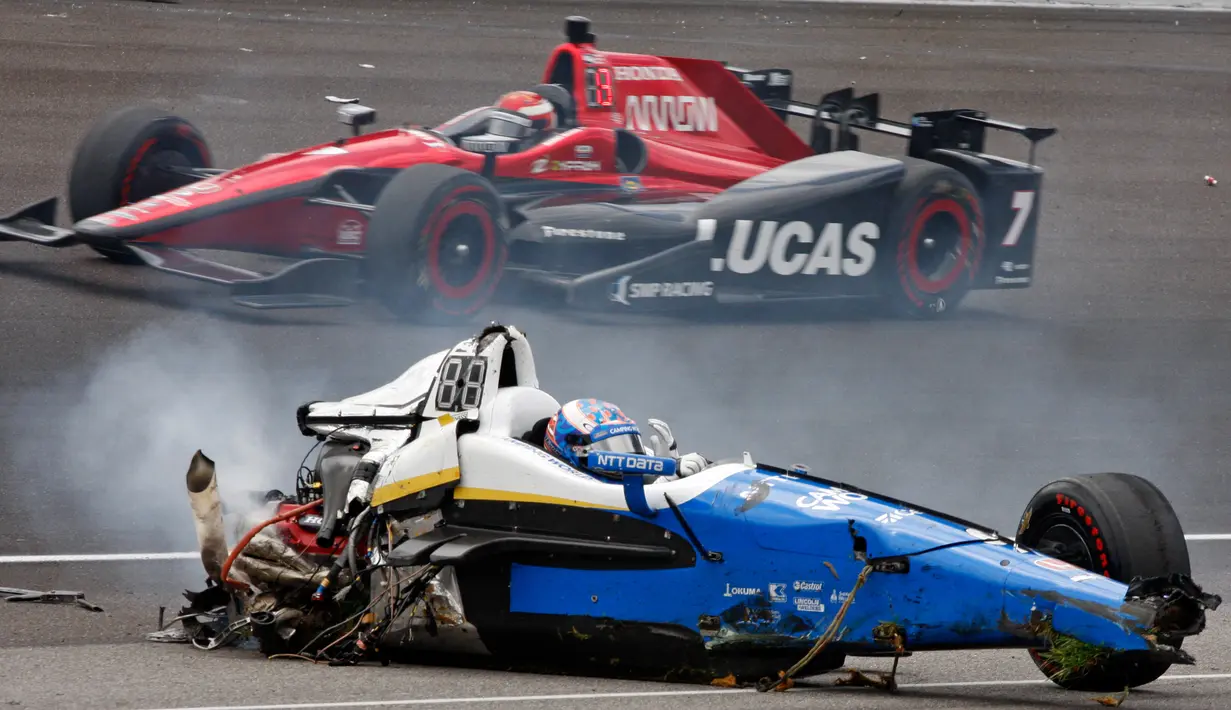 Pembalap Selandia Baru, Scott Dixon duduk dibangkai mobilnya usai mengalami tabrakan saat mengikuti balapan Indianapolis 500 di Indianapolis Motor Speedway (28/5). (AP Photo / Bud Cunningham)