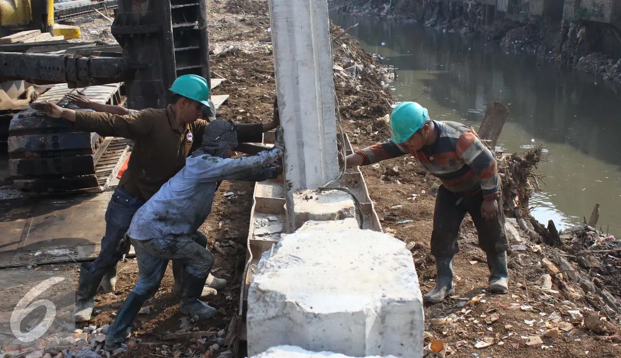Sejumlah pekerja memasang tiang pancang untuk turap bantaran Kali Ciliwung, Kampung Pulo, Jakarta (26/8/2015). Pemprov DKI Jakarta menargetkan pemasangan turap selesai dalam waktu tiga bulan. (Liputan6.com/Gempur M Surya)