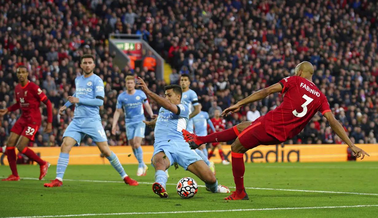 Pemain Manchester City Rodri memblok tembakan ke gawang terbuka dari pemain Liverpool Fabinho pada pertandingan Liga Inggris di Anfield, Liverpool, Inggris, Minggu (3/10/2021). Pertandingan berakhir imbang 2-2. (Peter Byrne/PA via AP)