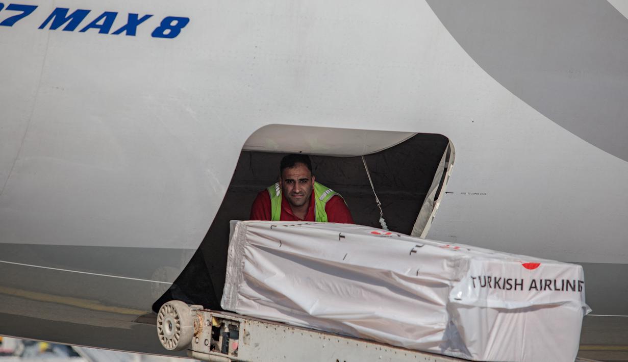 Peti mati berisi jenazah mantan pemain sepak bola internasional Ghana Christian Atsu dimuat ke pesawat menuju Ghana, di bandara Adana di selatan Turki, 18 Februari 2023. Ada laporan awal bahwa mantan pemain Chelsea dan Newcastle telah diselamatkan sehari setelah gempa, tetapi ternyata tidak benar. (AFP/Can Erok)