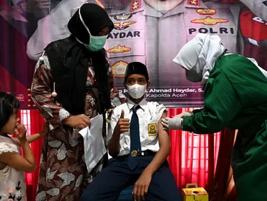 Seorang siswa sekolah menengah pertama menerima dosis vaksin Sinovac pada acara vaksinasi virus corona COVID-19 di Blang Bintang, Provinsi Aceh, 21 September 2021. (CHAIDEER MAHYUDDIN/AFP)