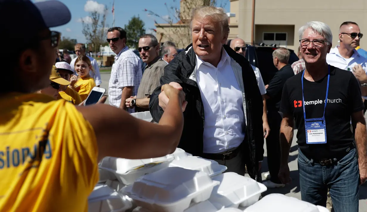 Presiden AS, Donald Trump bersalaman saat mengunjungi Gereja Baptis Kuil tempat persediaan makanan dan lainnya untuk diberikan kepada korban badai Florence di Temple Baptist Church di New Bern, N.C. (19/9). (AP Photo /Evan Vucci)