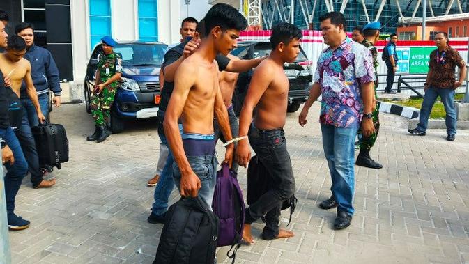 Tersangka penyelundupan sabu dalam sepatu dibawa polisi dari Bandara Pekanbaru. (Liputan6.com/M Syukur)