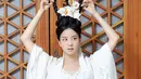 Rambut bintang drama Snowdrop ini dipermanis dengan bunga-bunga berwarna putih yang senada dengan gaunnya. [Dok/YG Entertainment]