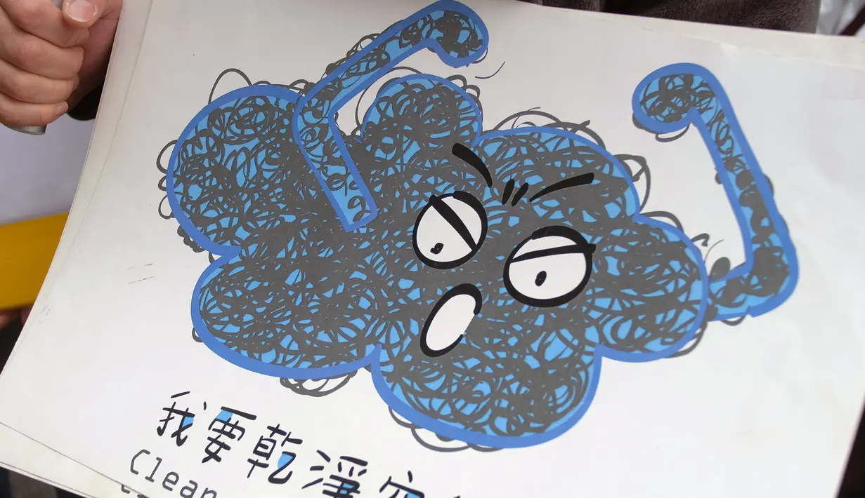 Seorang pengunjuk rasa membawa poster saat demonstrasi menuntut pemerintah Taiwan untuk pengurangan polusi udara di Taipei (26/12). Ratusan warga berbaris di jalan-jalan memprotes kebijakan energi pemerintah. (AFP PHOTO/Sam Yeh)