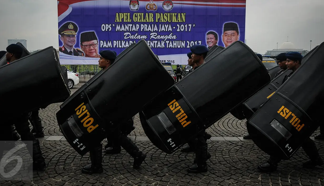 Sejumlah anggota Polisi Anti Huru-hara membawa perlengkapan seperti tameng saat mengikuti apel gelar pasukan ops Mantap Praja Jaya dalam rangka PAM Pilkada Serentak 2017 di Lapangan Monas, Jakarta, Rabu (12/10). (Liputan6.com/Faizal Fanani)