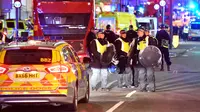 Polisi dengan perisai anti huru hara di Borough High Street setelah teror di London tengah, Sabtu (3/6). Serangan teror terjadi di London Bridge dan Borough Market, yang dilakukan lima orang pria. (AP Photo/ Matt Dunham). (Dominic Lipinski/PA via AP)
