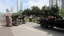 Mobil derek menarik mobil boks yang terguling Jalan Casablanca, Jakarta, Rabu (27/6). Mobil bernomor polisi B 9515 FCC terguling setelah menabrak pembatas jalan. (Liputan6.com/Arya Manggala)