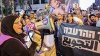 Seorang wanita berbicara melalui megafon ketika para aktivis Israel berbaris dengan membawa karung-karung tepung menuju markas besar Kementerian Pertahanan Israel di Tel Aviv pada 22 Juli 2025. (Jack GUEZ/AFP)