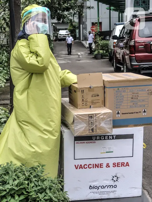 Petugas menjaga dus berisi vaksin COVID-19 produksi Sinovac di Gedung Dinas Kesehatan DKI Jakarta, Rabu (13/1/2021). Dinas Kesehatan DKI Jakarta mulai mendistribusikan vaksin COVID-19 ke seluruh puskesmas di Ibu Kota. (merdeka.com/Iqbal S. Nugroho)