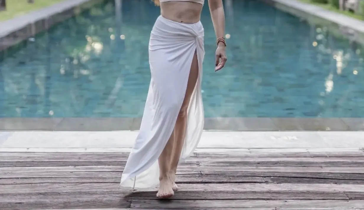 Kali ini, ia tampil stunning dengan crop top dan wrap skirt serba putih. [Foto: IG/wulanguritno].