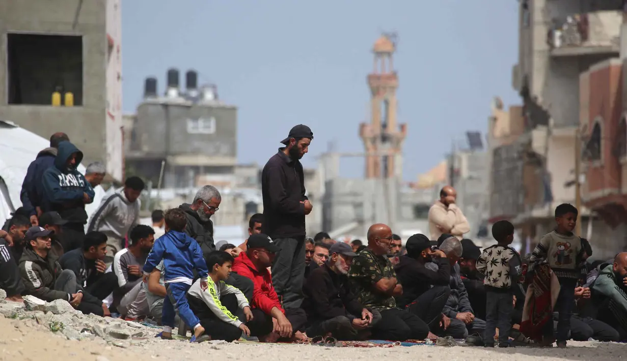 Umat Muslim Palestina berdoa saat salat Jumat terakhir di bulan suci Ramadan 1447 Hijriah, di luar Masjid Al-Talbani, yang dihancurkan oleh militer Israel di Khan Yunis, Jalur Gaza selatan pada Jumat 13 Maret 2026. Memasuki Jumat terakhir di bulan suci Ramadan 1447 Hijriah, umat Muslim di Gaza tetap menunjukkan keteguhan dalam menjalankan ibadah. (Bashar Taleb/AFP)