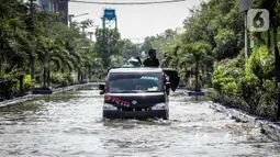 Kendaraan bermotor melintasi jalan yang tergenang air rob (banjir pasang air laut) di Kawasan Pasar Ikan Muara Baru, Jakarta, Kamis (4/6/2020). Banjir rob di Pelabuhan Muara Baru tersebut terjadi akibat cuaca ekstrem serta pasangnya air laut. (Liputan6.com/Faizal Fanani)