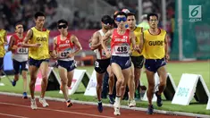 Pelari 5000 meter putra kategori T11 Asian Para Games 2018 saat laga final di SUGBK, Jakarta, Jumat (12/10). T11 adalah klasifikasi pelari disabilitas netra, karenanya dalam setiap lomba didampingi pemandu atau guide. (Liputan6.com/Helmi Fithriansyah)